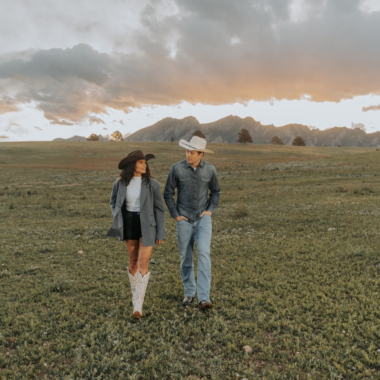 Our Beliefs | Woman and man walking the fields of the midwest in cowboy hats and Dan Post Boots }}