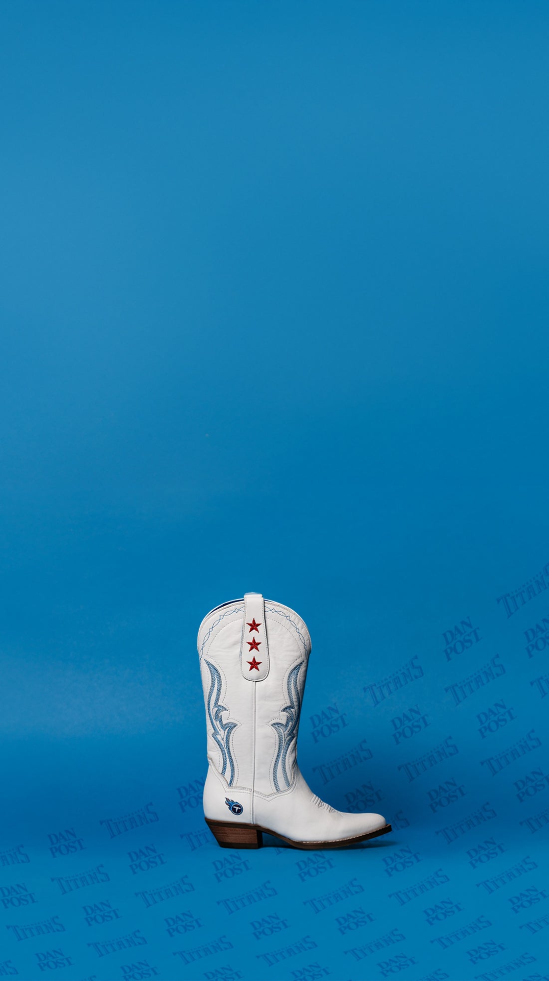 Dan Post x Tennessee Titans themed boot, white leather with red star design sitting on a blue background